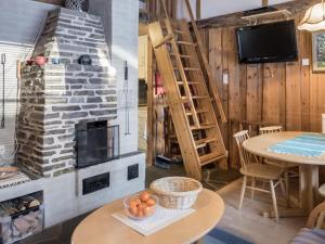 - un salon avec une cheminée en pierre et une table dans l'établissement Holiday Home Vuokatinportti b 8 by Interhome, à Vuokatti