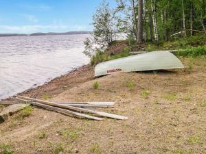 a boat on the shore of a body of water at Holiday Home Villa salix by Interhome in Mäntyharju