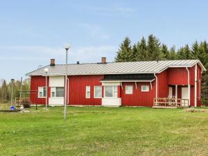 ein rotes Haus mit einem Feld davor in der Unterkunft Holiday Home Itäkoski 2 by Interhome in Itäkoski