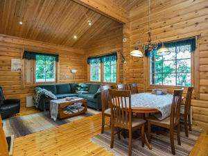 a dining room and living room in a log cabin at Holiday Home Hirsiniemi by Interhome in Vuoriniemi