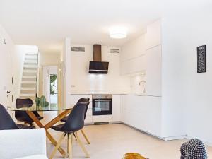 - une cuisine blanche avec une table et des chaises en verre dans l'établissement Apartment Pueblo Arabesque-8 by Interhome, à Marbella
