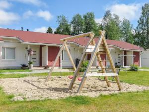 a wooden swing set in front of a house at Holiday Home Tapiska by Interhome in Taivalkoski