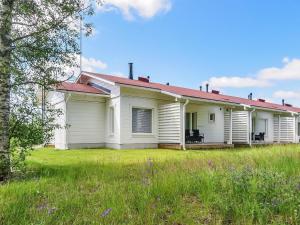 an old white house with a grass yard at Holiday Home Tapiska by Interhome in Taivalkoski