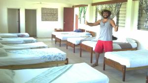Ein Mann steht in einem Raum mit Reihen von Matratzen. in der Unterkunft Bamboo Backpackers in Nadi