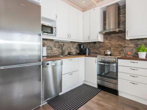 a kitchen with white cabinets and stainless steel appliances at Holiday Home Villa ina by Interhome in Evijärvi