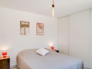 a white bedroom with a bed and two red lamps at Apartment Palazzo Ribotti by Interhome in Nice