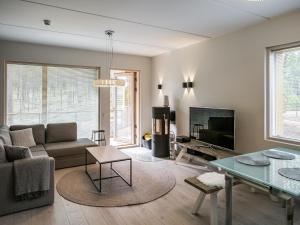 ein Wohnzimmer mit einem Sofa und einem TV in der Unterkunft Holiday Home Tunturinlaita d4 by Interhome in Sirkka