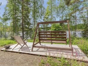 un columpio y una silla en una plataforma de madera en Holiday Home Paavolanniemi by Interhome en Kotalahti