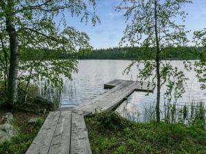 un muelle de madera en un lago con árboles en Holiday Home Koivuniemen rouva by Interhome en Rahula