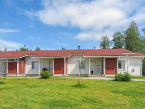 una casa con techo rojo y patio en Holiday Home Tapiska by Interhome en Taivalkoski
