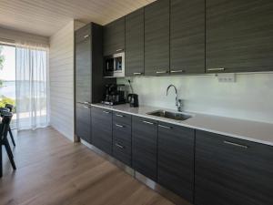 a kitchen with dark wood cabinets and a sink at Holiday Home Kasnäs marina b 16 by Interhome in Kasnäs