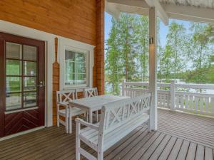 een veranda met een witte tafel en stoelen erop bij Holiday Home Paavolanniemi by Interhome in Kotalahti