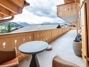 a balcony with a table and chairs and mountains at Apartment Grace by Interhome in Gstaad