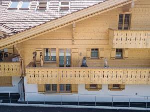 a wooden house with statues on the balcony at Apartment Grace by Interhome in Gstaad