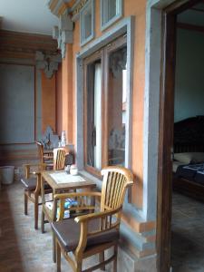 grupa drewnianych stołów i krzeseł w pokoju w obiekcie Pica Sedana Homestay w mieście Ubud