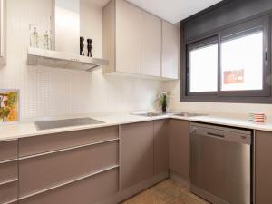a kitchen with white cabinets and a sink and a window at Holiday Home Sol Cambrils Park-6 by Interhome in Cambrils