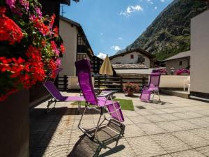 a group of purple chairs sitting on a patio at Apartment Zur Post by Interhome in Saas-Almagell