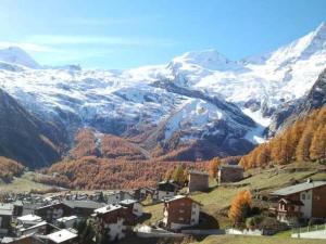 a small town in a valley with snow covered mountains at Apartment Bijou by Interhome in Saas-Fee