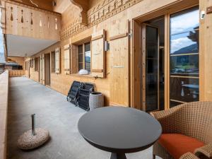 a room with a table and chairs on a balcony at Apartment Grace by Interhome in Gstaad