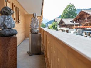 dwa posągi siedzące na krawędzi budynku w obiekcie Apartment Grace by Interhome w mieście Gstaad
