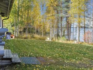 ein Haus mit einem Rasen mit Bäumen und einer Wasserfläche in der Unterkunft Holiday Home Markenniemi by Interhome in Ahveninen