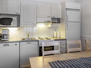 a kitchen with white cabinets and white appliances at Holiday Home Lepolinna b by Interhome in Tahkovuori