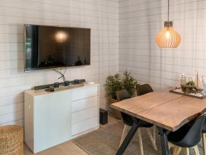 a dining room with a table and a tv on a wall at Holiday Home Kasnäs marina a 6 by Interhome in Salo