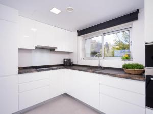 cocina blanca con fregadero y ventana en Villa Lirios by Interhome, en Benitachell