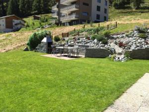 a yard with green grass and a building at Apartment Bijou by Interhome in Saas-Fee