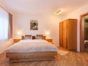 a bedroom with a large bed and a wooden cabinet at Apartment Apartment Bristolino by Interhome in Saas-Fee