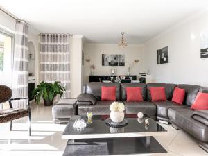 ein Wohnzimmer mit einem Ledersofa und roten Kissen in der Unterkunft Apartment Les Pins D'Alep by Interhome in Le Cannet