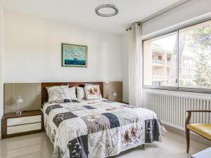 ein Schlafzimmer mit einem Bett und einem Fenster in der Unterkunft Apartment Les Pins D'Alep by Interhome in Le Cannet
