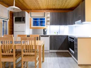 a kitchen with a wooden table and chairs at Holiday Home Albatrossi by Interhome in Sirkka