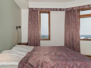 a bedroom with a bed and two windows at Holiday Home Ylläs chalets 2301 by Interhome in Ylläsjärvi