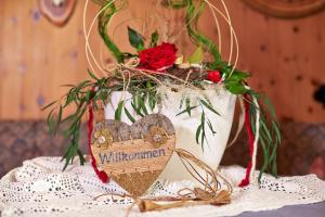 un vase blanc avec un cœur et des fleurs sur une table dans l'établissement Fremdenpension Alpenruhe, à Sölden