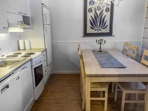 a kitchen with a table and a stove and a sink at Holiday Home Lepolinna b by Interhome in Tahkovuori