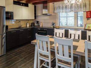 - une cuisine avec une table en bois et des chaises blanches dans l'établissement Holiday Home Rölli 2 by Interhome, à Äkäslompolo 21 autres photos