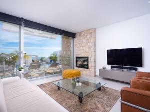sala de estar con sofá y TV en Villa Lirios by Interhome, en Benitachell