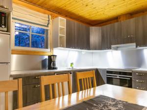 a kitchen with a wooden ceiling and a table and chairs at Holiday Home Albatrossi by Interhome in Sirkka