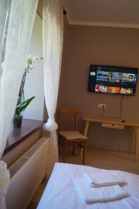 a room with a bed and a tv on the wall at Kuivižu Krogs - motelis in Salacgrīva