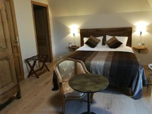 Un pat sau paturi într-o cameră la Auberge du Vieux Tour Le Manoir