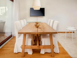 einen Esstisch mit weißen Stühlen und einen TV in der Unterkunft Holiday Home Villa Beach Front by Interhome in Savudrija