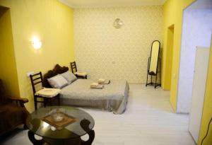 a bedroom with a bed and a table in a room at Guest House Happy Holidays in Tbilisi City