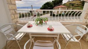 einen weißen Tisch und Stühle auf dem Balkon in der Unterkunft Apartments Slado in Omiš