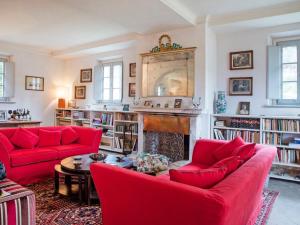a living room with red couches and a fireplace at Villa Ghizzano by Interhome in Peccioli