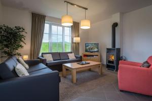 a living room with couches and a fire place at Villapark Vlašky in Bešeňová