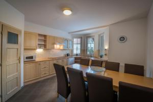 a large kitchen with a wooden table and chairs at Villapark Vlašky in Bešeňová