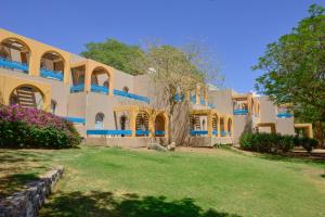 een groot gebouw met een boom ervoor bij Club In Eilat Resort - Executive Deluxe Villa With Jacuzzi, Terrace & Parking in Eilat