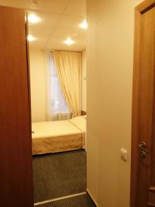 Kleines Zimmer mit einem Bett und einem Fenster in der Unterkunft Rinaldi Poetic in Sankt Petersburg