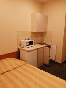 a small kitchen with a bed and a microwave on a counter at Rinaldi Poetic in Saint Petersburg